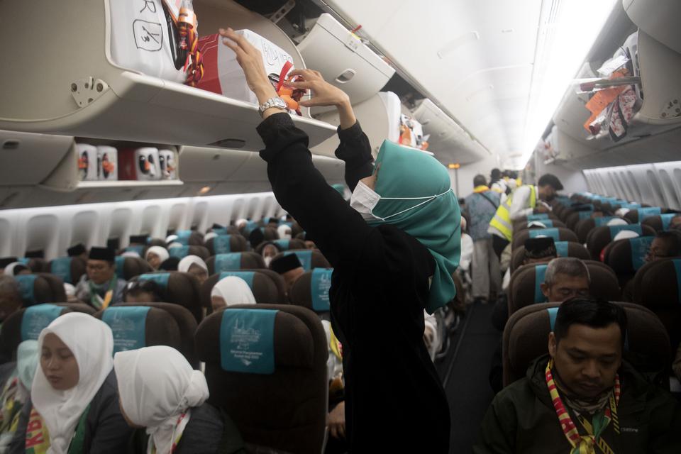 Seorang pramugari menata barang bawwan jamaah calon haji menaiki pesawat yang membawa ke Tanah Suci di Bandara Soekarno Hatta, Tangerang, Banten, Rabu (24/5/2023). 