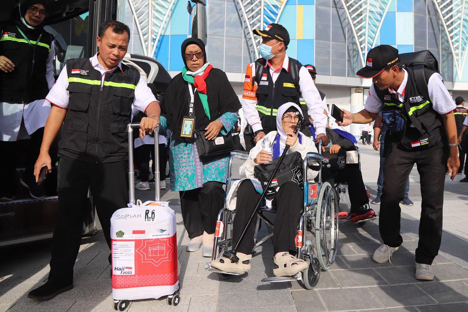 Petugas PPIH Arab Saudi membantu jamaah haji kloter pertama JKG 01 yang menggunakan kursi roda setibanya di Bandara Amir Muhammad bin Abdul Aziz (AMAA) Madinah, Arab Saudi, Rabu (24/5/2023). Sebanyak 390 jamaah dan empat petugas kloter tiba di Madinah unt
