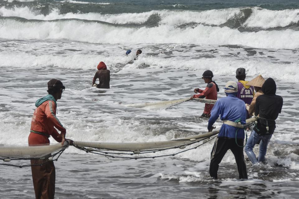 Nelayan tradisional menarik jaring ikan di Pantai Timur, Kabupaten Pangandaran, Jawa Barat, Sabtu (27/5/2023). Kementerian Kelautan dan Perikanan menargetkan penyerapan ikan hasil tangkapan nelayan sebanyak 14.252 ton pada tahun 2023 melalui program penan