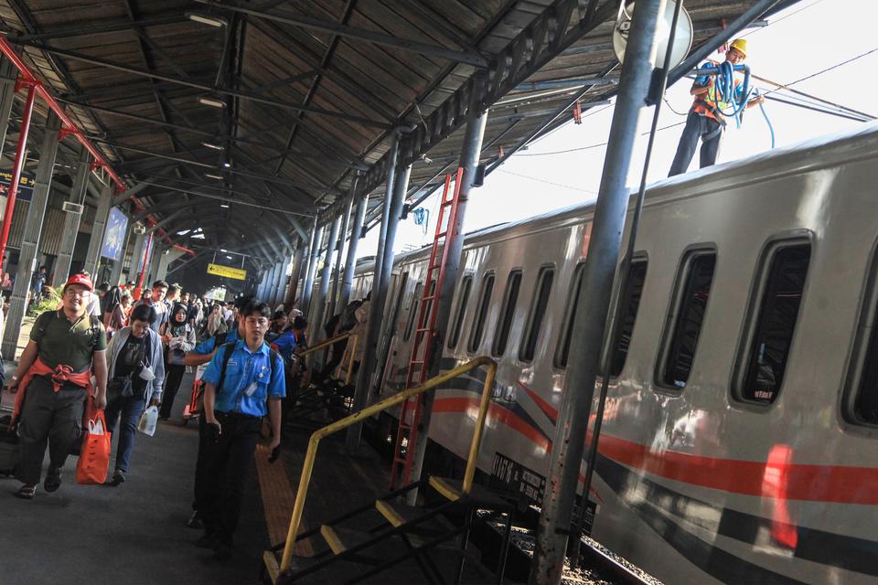 Penumpang berjalan di sebelah gerbong kereta api usai tiba di Stasiun Tawang, Semarang, Jawa Tengah, Rabu (28/6/2023). 