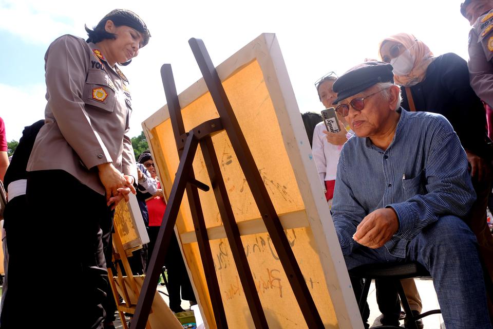 Budayawan sekaligus pengasuh Pondok Pesantren Raudlatuh Tholibin Rembang KH Mustofa Bisri (Gus Mus) sedang melukis, di Alun-alun Kota Magelang, Jawa Tengah, Minggu (2/7/2023).