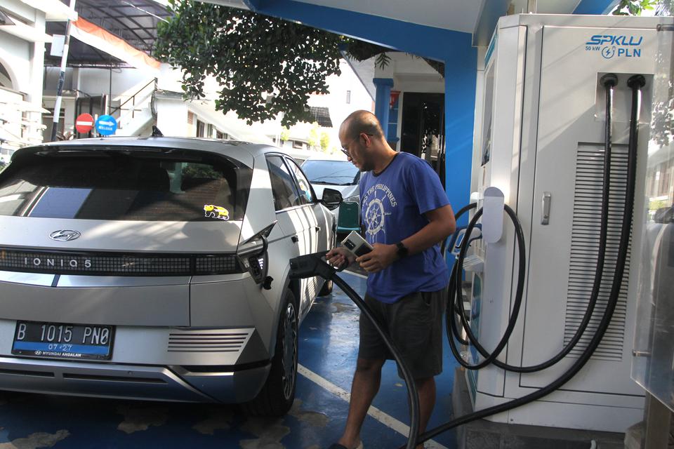 Pemilik mobil mengisi ulang baterai kendaraan listrik di Stasiun Pengisian Kendaraan Listrik Umum (SPKLU) di halaman Kantor PLN Unit Pelaksanaan Pelayanan Pelanggan (UP3) Malang, Jawa Timur, Selasa (11/7/2023). 
