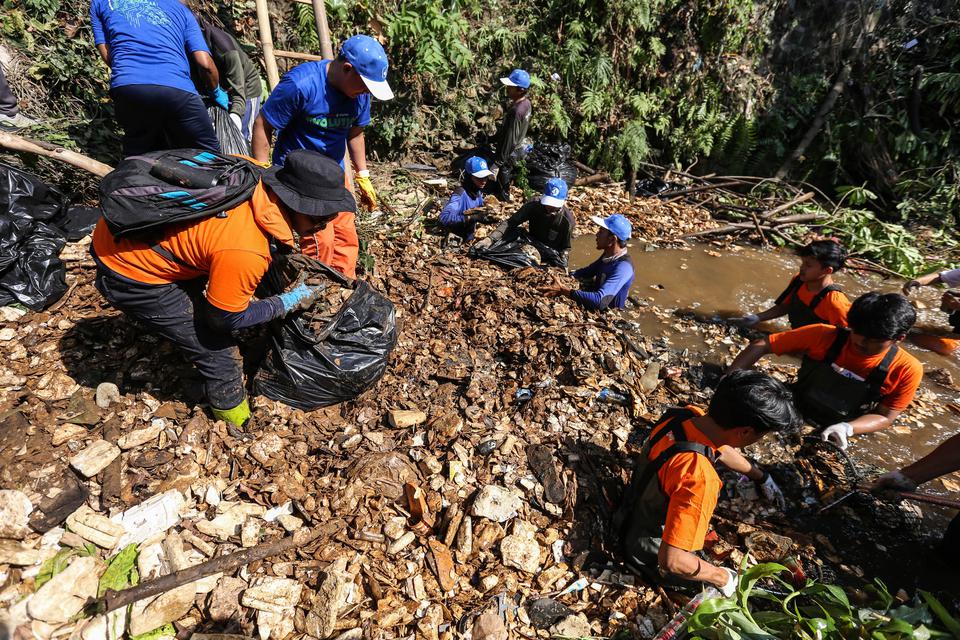 Karyawan Pupuk Kalimantan Timur (PKT) bersama anggota Pandawara Group membersihkan sampah yang memadati Kali Krukut, Depok, Jawa Barat, Selasa (18/7/2023). Pupuk Kalimantan Timur (PKT) berkolaborasi dengan Pandawara Group menggelar kegiatan Employee Volun