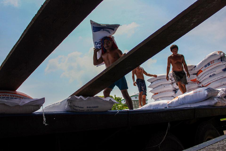 Sejumlah pekerja mengangkut beras dalam karung di gudang Bulog Medan, Sumatera Utara, Jumat (21/7/2023). 