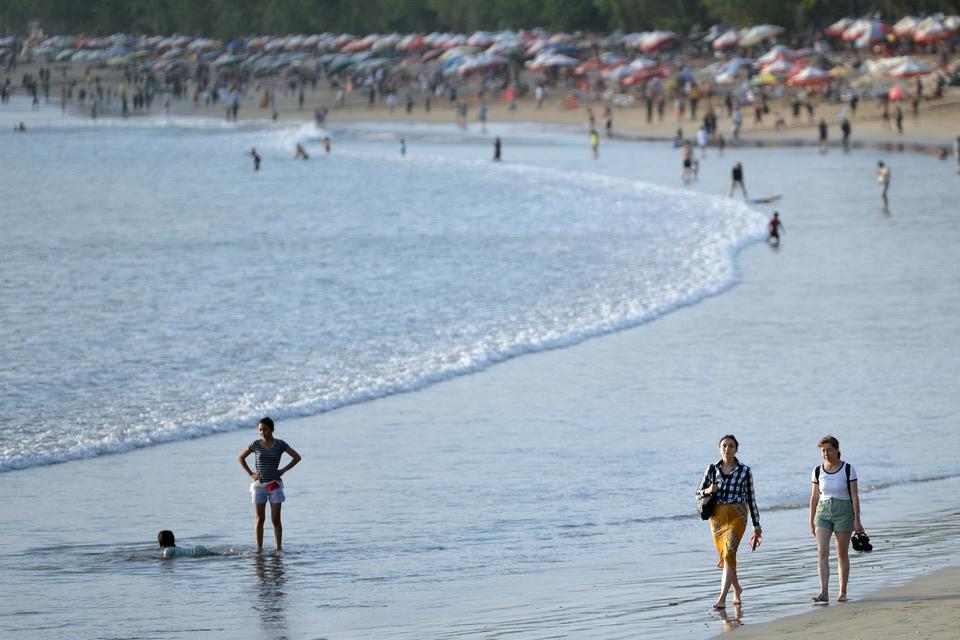 Wisatawan mancanegara (wisman) berjalan di tepi Pantai Kuta, Badung, Bali, Selasa (25/7/2023). Pemerintah Provinsi Bali berencana akan mengenakan pungutan retribusi sebesar Rp150 ribu atau 10 dollar AS bagi setiap wisman yang masuk Bali untuk perlindungan