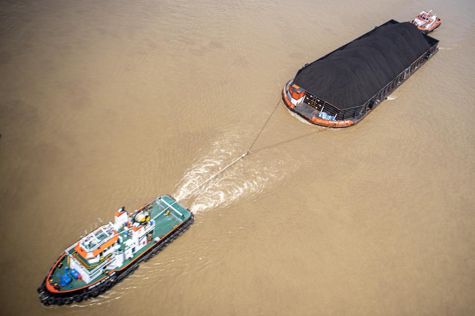 Kapal tongkang pengangkut batu bara melintas di Sungai Musi, Palembang, Sumatera Selatan, Kamis (27/7/2023). 
