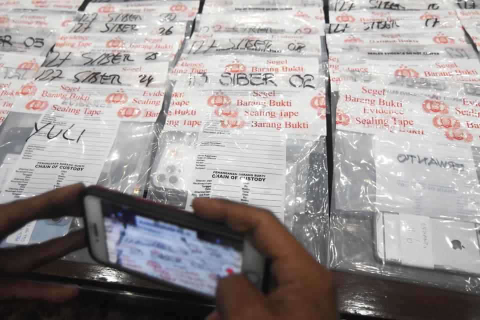 Wartawan mengambil gambar barang bukti saat konferensi pers tindak pidana Ilegal Akses Sistem CEIR (Centralized Equipment Identity Register) untuk mendaftarkan IMEI di Kementerian Perindustrian, di Gedung Bareskrim Mabes Polri, Jakarta, Jumat (28/7/2023).
