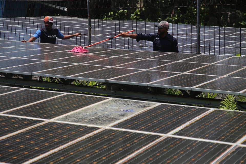 Petugas membersihkan panel Pembangkit Listrik Tenaga Surya (PLTS) di Kelurahan Tomajiko, Pulau Hiri, Maluku Utara, Minggu (30/7/2023). 