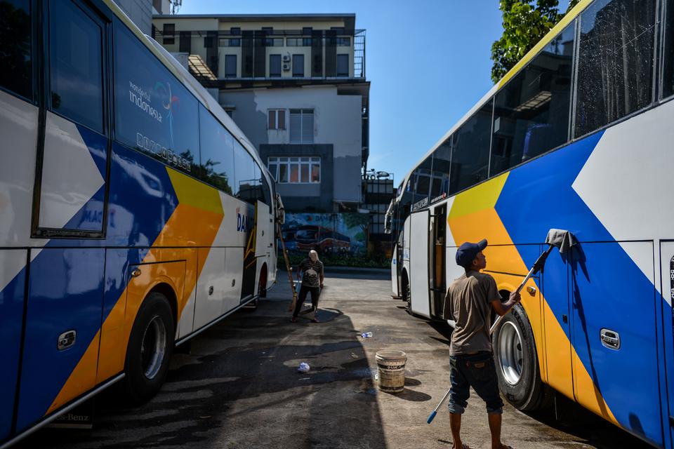 Pekerja membersihkan armada bus DAMRI di pool bus damri Kebon Kawung, Bandung, Jawa Barat, Selasa (1/8/2023). Perum DAMRI menyediakan layanan transportasi menuju Bandara Kertajati dari sejumlah kota termasuk Kota Bandung guna memudahkan masyarakat yang i
