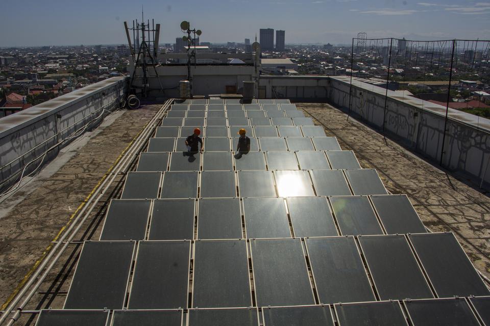 Petugas melakukan perawatan terhadap panel surya di atap gedung Hotel Claro, Makassar, Sulawesi Selatan, Rabu (2/8/2023). Kementerian ESDM mencatat pemanfaatan Pembangkit Listrik Tenaga Surya (PLTS) atap secara nasional hingga Mei 2023 telah mencapai 95 m