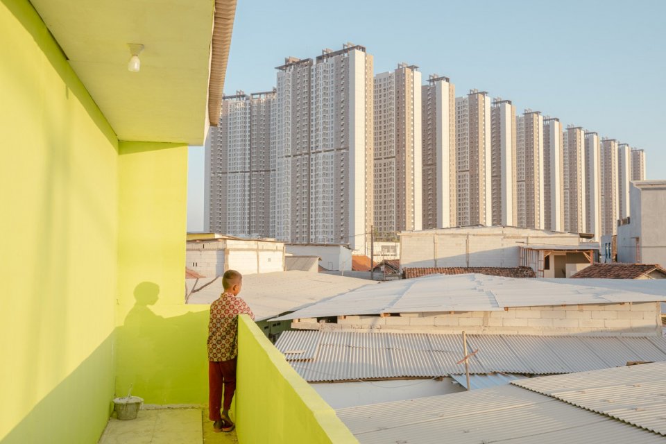 Seorang anak berdiri di teras rumah kontrakan di Kampung Muara, Teluknaga, Tangerang, Selasa (2/8). Ratusan kepala keluarga di lokasi yang berdekatan dengan Tokyo Apartemen Pantai Indah Kapuk (PIK) 2 akan direlokasi pengembang, sebelumnya tahun 2016 seban