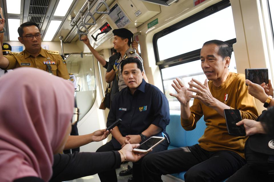 Presiden Joko Widodo (kanan) didampingi Menteri BUMN Erick Thohir (kedua kanan) berbincang dengan sejumlah wartawan saat naik LRT Jabodetabek di Jakarta, Kamis (3/8/2023). Presiden menggunakan moda transportasi LRT dengan rute Stasiun Harjamukti hingga St