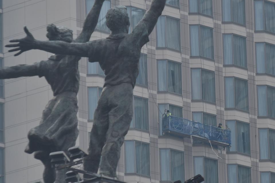 Sejumlah pekerja membersihkan kaca gedung di kawasan Bundaran HI, Jakarta, Selasa (8/8/2023). 