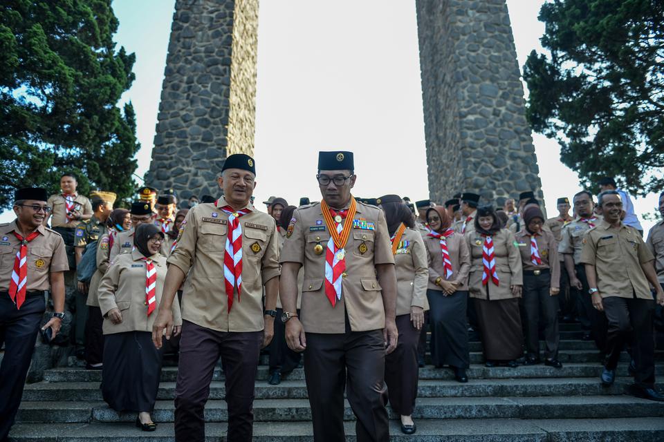 Gubernur Jawa Barat Ridwan Kamil (tengah) berjalan usai mengikuti upacara peringatan Hari Pramuka di Taman Makam Pahlawan di Cikutra, Bandung, Jawa Barat, Senin (14/8/2023).