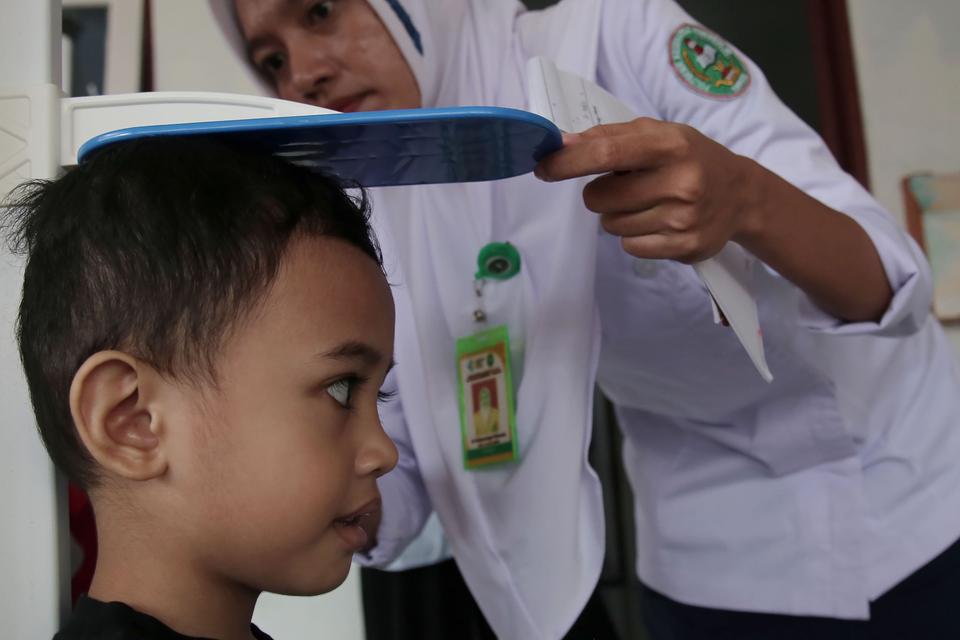 Petugas kesehatan mengukur tinggi badan balita saat pelaksanaan pos pelayanan terpadu (posyandu) di Kota Ternate, Maluku Utara, Rabu (16/8/2023). 