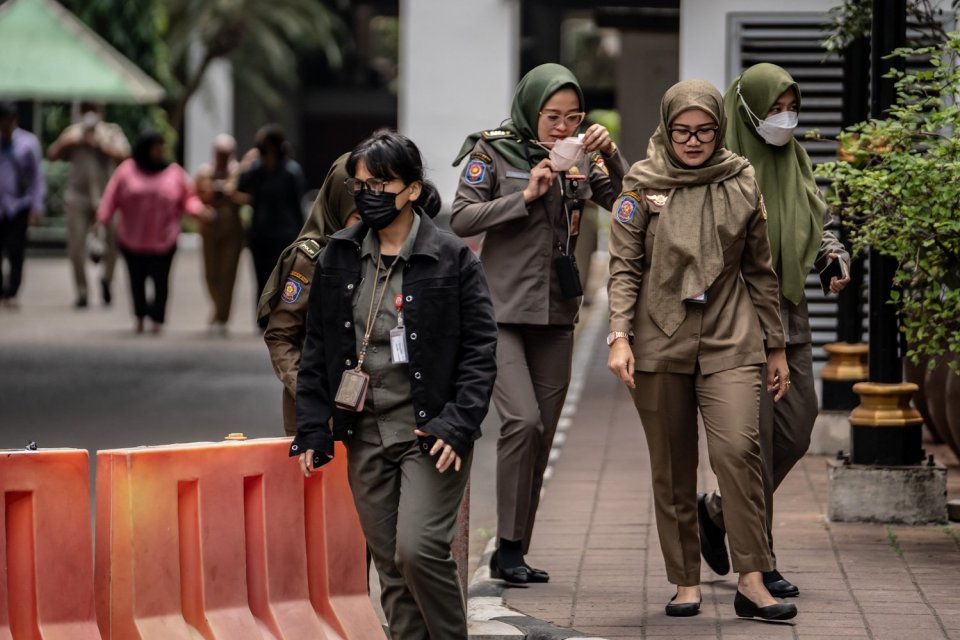 Pegawai Negeri Sipil (PNS) berjalan di kompleks Balai Kota DKI Jakarta, Senin (21/8). 