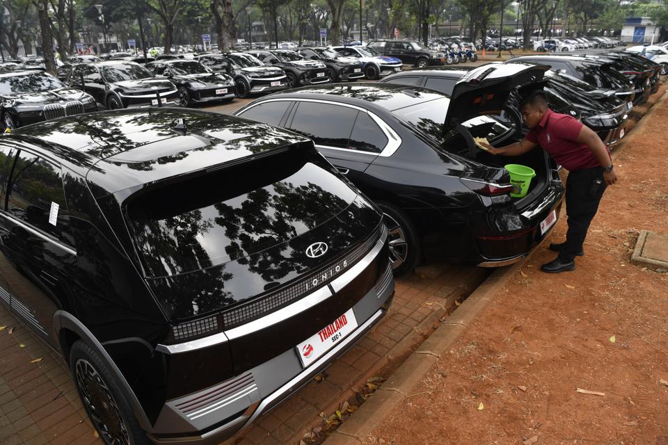 Petugas membersihkan kendaraan listrik delegasi KTT ASEAN di area Parkir Gelora Bung Karno, Jakarta, Jumat (1/9/2023).