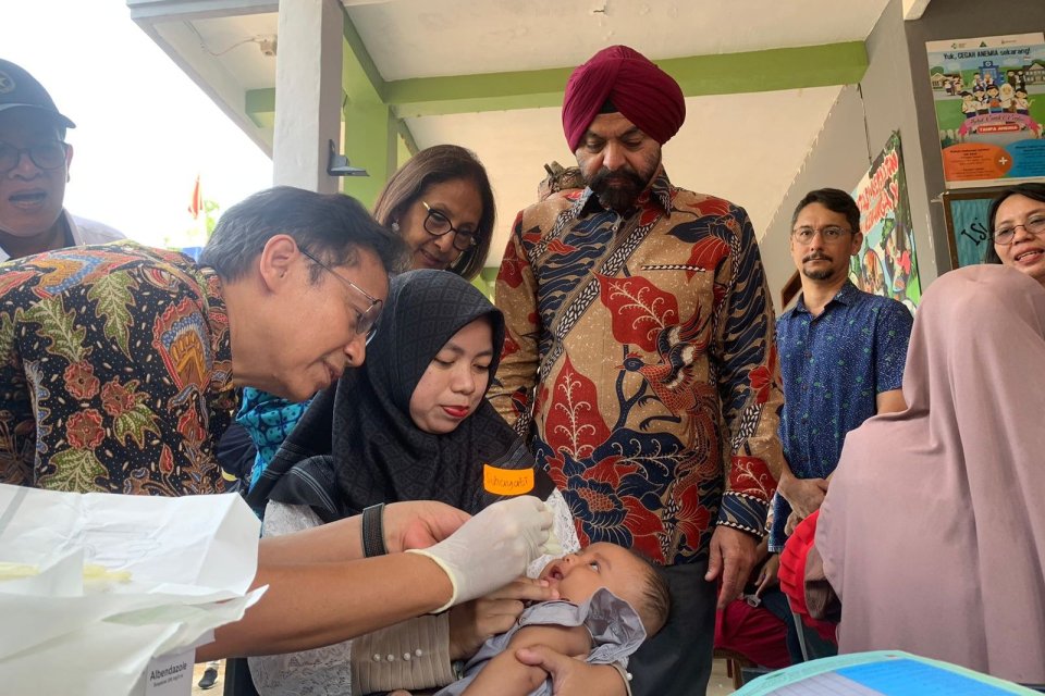 Menteri Kesehatan Budi Gunadi Sadikin, disaksikan Presiden Bank Dunia Ajay Banga (berturban merah), memberi vaksin polio pada bayi di Desa Serdang Kulon, Tangerang, Banten, Kamis (7/9).