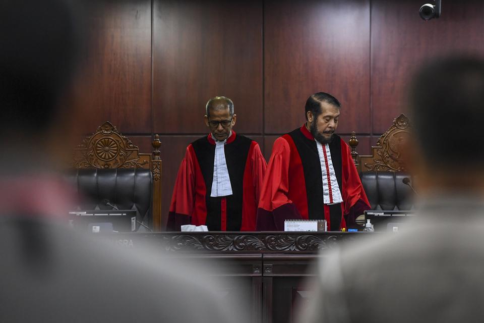 Ketua Majelis Hakim Mahkamah Konstitusi (MK) Anwar Usman (kanan) dan Wakil Ketua MK Saldi Isra (kiri) bersiap memimpin jalannya sidang putusan Pengujian Materiil Undang-Undang Nomor 22 Tahun 2009 tentang Lalu Lintas dan Angkutan Jalan di Gedung MK, Jakart