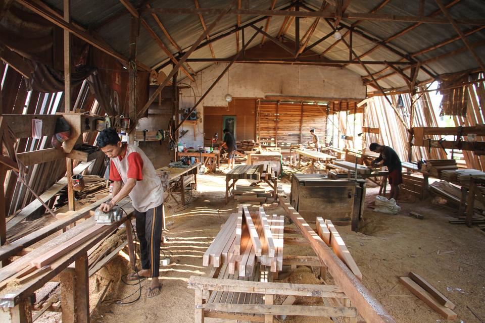 Pekerja menyelesaikan pembuatan furnitur kayu di mebel Cahaya Indah Jaya, Palangka Raya, Kalimantan Tengah, Senin (18/9/2023). 