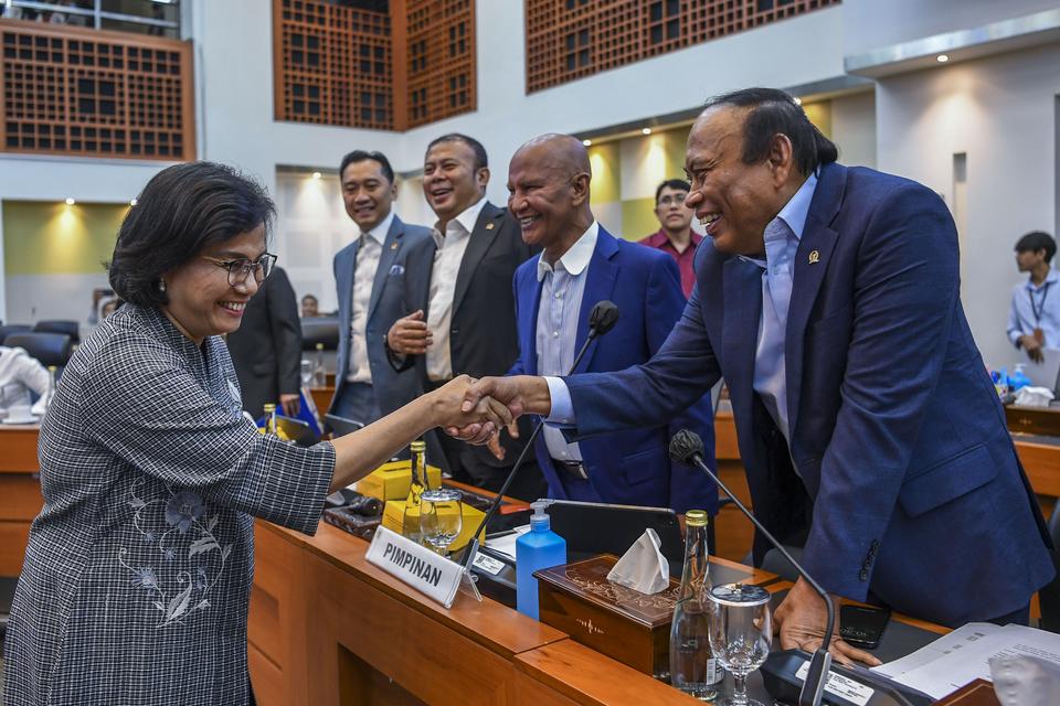 Menteri Keuangan Sri Mulyani (kiri) berjabat tangan dengan Wakil Ketua Banggar Muhidin Mohamad Said (kanan) disaksikan Ketua Banggar Said Abdullah (kedua kanan), dan Wakil Ketua Banggar Cucun Ahmad Syamsuril (tengah) dan Edhie Baskoro Yudhoyono (kedua kir