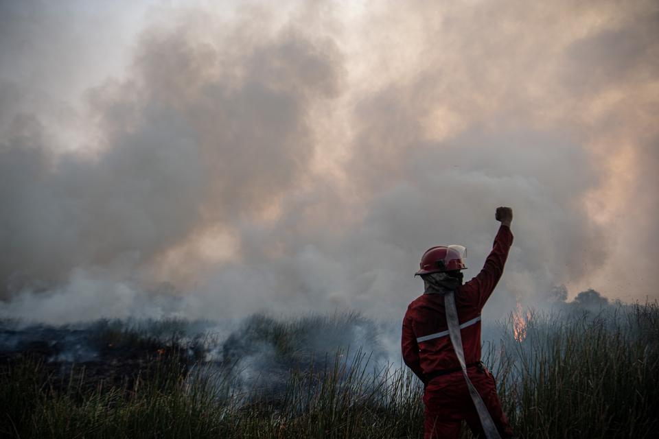 Petugas Manggala Agni Daops Banyuasin memberikan kode saat berupaya memadamkan kebakaran lahan di Desa Muara dua, Kecamatan Pemulutan, Kabupaten Ogan Ilir (OI), Sumatera Selatan, Kamis (21/9/2023). Berdasarkan data dari Balai Pengendalian Perubahan Iklim 