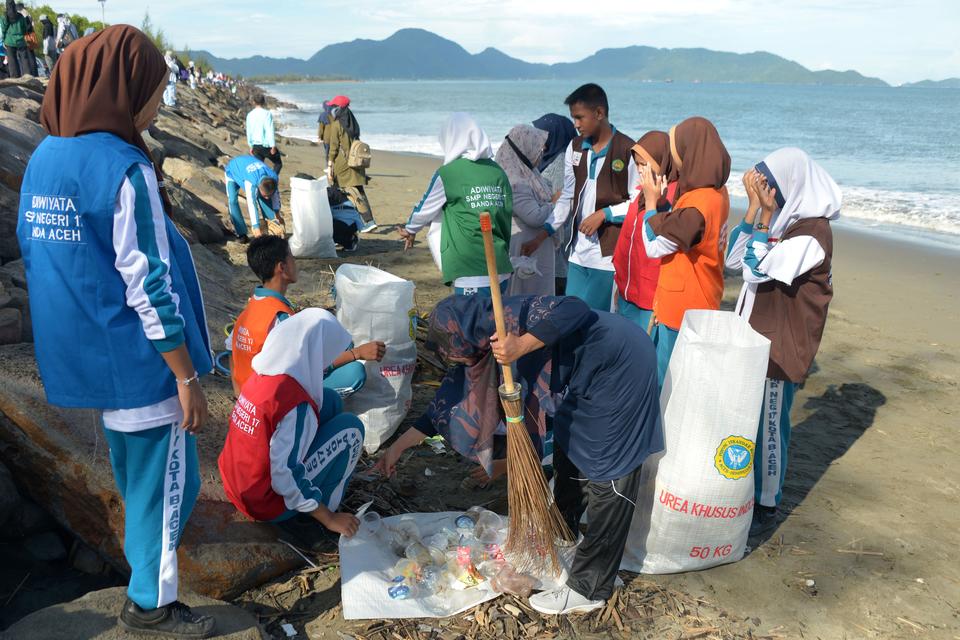 Pelajar memungut sampah plastik dan organik saat aksi bersih pantai di pesisir Kampung Jawa, Banda Aceh, Aceh, Sabtu (23/9/2023).