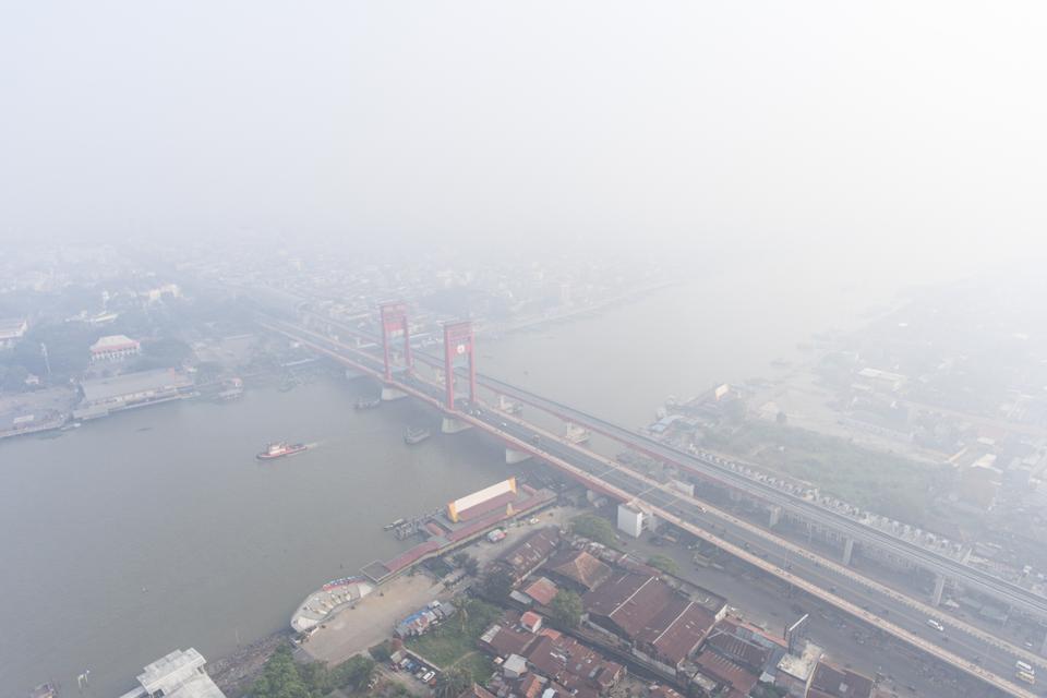 Foto udara jembatan Ampera yang tertutup kabut asap di Palembang, Sumatera Selatan, Minggu (1/10/2023). Berdasarkan data dari Badan Meteorologi, Klimatologi, dan Geofisika kualitas udara di Palembang berada di level berbahaya dampak dari Kebakaran Hutan d