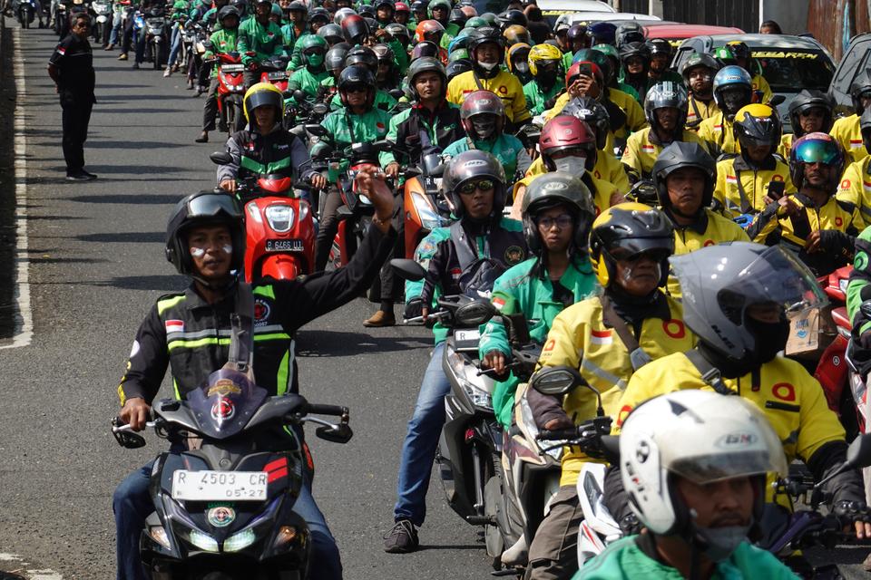 Sejumlah pengemudi ojek online melakukan unjuk rasa menuntut penyesuaian tarif di ruas Jalan S. Parman, Purwokerto, Banyumas, Jawa Tengah, Selasa (3/10/2023). Pengemudi ojek online yang tergabung dalam Dewan Presidium Driver Ojek Online Banyumas Raya juga