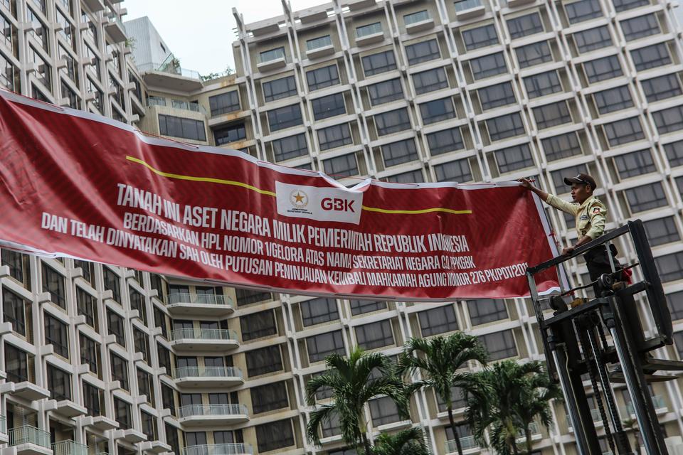 Petugas memasang spanduk pemberitahuan di depan Hotel Sultan, Kompleks GBK, Jakarta, Rabu (4/10/2023). Pusat Pengelolaan Kompleks Gelora Bung Karno (PPKGBK) memasang spanduk pemberitahuan tanah aset negara di Hotel Sultan, dan mengingatkan pengelola hotel