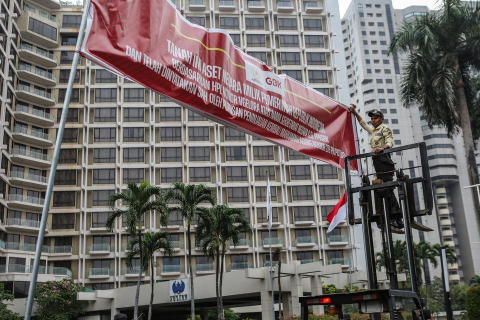 Petugas memasang spanduk pemberitahuan di depan Hotel Sultan, Kompleks GBK, Jakarta, Rabu (4/10/2023). Pusat Pengelolaan Kompleks Gelora Bung Karno (PPKGBK) memasang spanduk pemberitahuan tanah aset negara di Hotel Sultan, dan mengingatkan pengelola hotel