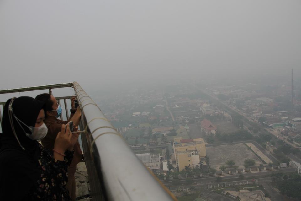 Warga melihat suasana kota diselimuti kabut asap di Palangka Raya, Kalimantan Tengah, Rabu (4/10/2023). Berdasarkan data dari aplikasi ISPUnet Kementerian Lingkungan Hidup dan Kehutanan (KLHK), kualitas udara di kota itu masuk kategori berbahaya dengan ni