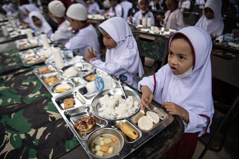 Sejumlah siswa Sekolah Dasar (SD) menyantap makanan saat pelaksanaan program dapur masuk sekolah di SD Negeri 205, Kertapati, Palembang, Sumatera Selatang, Jumat (6/10/2023). Program Dapur Masuk Sekolah yang digagas Kodam II/Sriwijaya tersebut bertujuan u