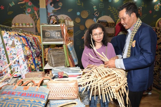 Pengunjung belajar menganyam di salah satu booth mitra binaan UMKM Pertamina saat acara “Inacraft on October 2023” yang diselenggarakan di JCC, Senayan, Jakarta pada Rabu (4/10).