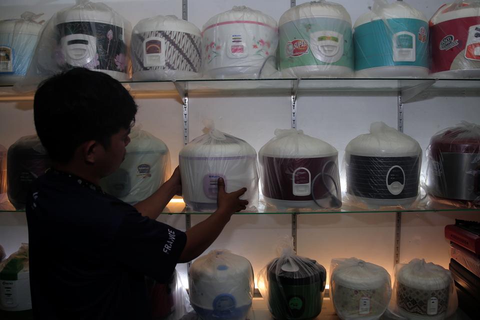 Pekerja menata alat masak nasi listrik atau rice cooker yang dijual di salah satu tokoh di Kota Ternate, Maluku Utara, Kamis (12/10/2023). Pemerintah melalui Kementerian ESDM akan membagikan sebanyak 500 ribu unit rice cooker gratis kepada masyarakat yang