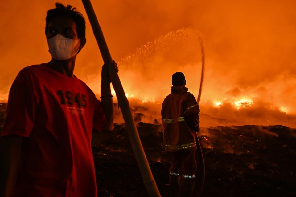 Sejumlah petugas pemadam kebakaran berupaya memadamkan api di TPA Rawa Kucing, Kota Tangerang, Banten, Jumat (20/10/2023). Sebanyak 25 unit mobil pemadam kebakaran dikerahkan untuk memadamkan api di tempat pembuangan akhir seluas 35 hektar yang menampung 