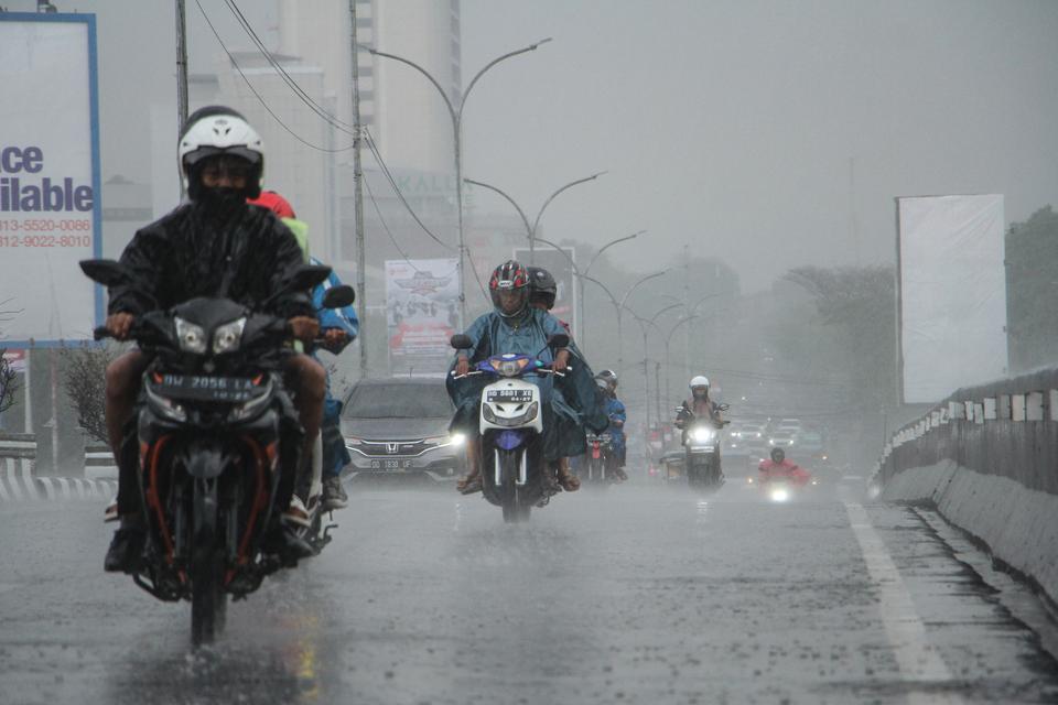 Sejumlah pengendara menerobos hujan di Makassar, Sulawesi Selatan, Selasa (24/10/2023). Sebagian besar wilayah Makassar mulai diguyur hujan dengan intensitas ringan, sementara Badan Meteorologi, Klimatologi dan Geofisika (BMKG) Wilayah IV Makassar memprak