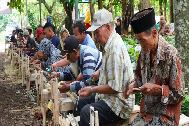 Para lansia yang diberdayakan oleh Grup MIND ID PTBA tampak khidmat melakukan aktivitas menyulap bambu menjadi tusuk sate. 