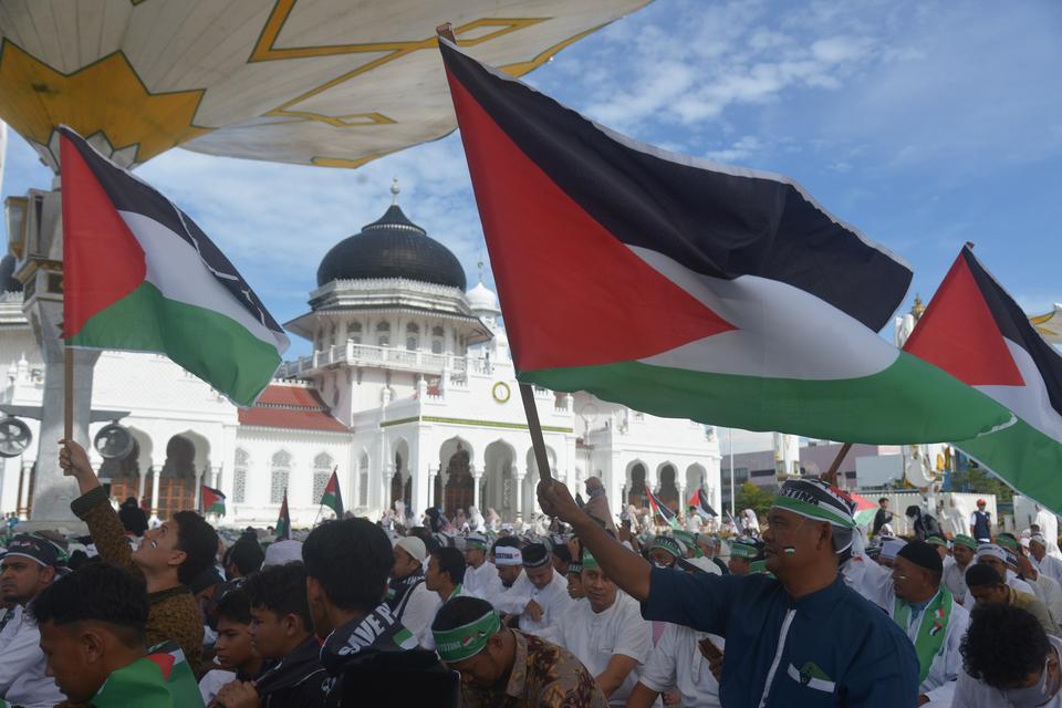Warga mengibarkan bendera Palestina sebelum menggelar doa bersama di Masjid Raya Baiturrahman, Banda Aceh, Kamis (2/11/2023). Doa bersama dan penggalangan dana tersebut sebagai wujud kepedulian dan menyerukan kepada PBB agar berperan aktif guna mengakhir