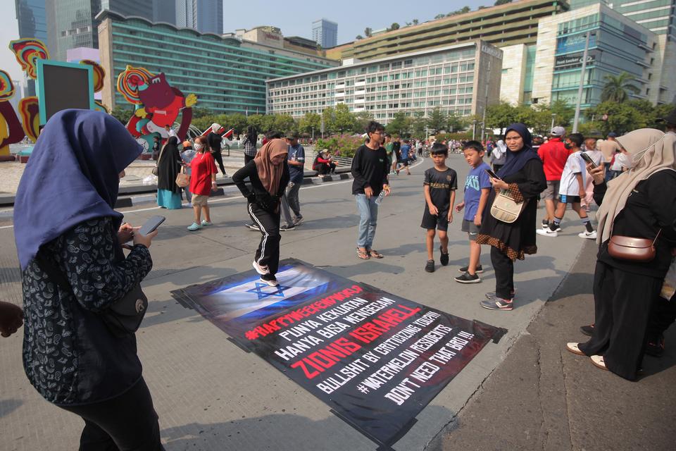 Ilustrasi. Masyarakat melakukan aksi injak spanduk bergambar bendera Israel di Car Free Day, Jakarta, Minggu (12/11/2023). Kegiatan tersebut sebagai bentuk solidaritas untuk rakyat Palestina terhadap serangan Israel ke kota Gaza, Palestina. 