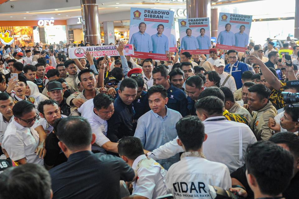 Bakal calon wakil presiden dari Koalisi Indonesia Maju (KIM) Gibran Rakabuming Raka (tengah) berjabat tangan dengan para pendukungnya saat acara gabungan relawan bertajuk "Gibran Mendengar" di salah satu pusat perbelanjaan di Palembang, Sumatera Selatan