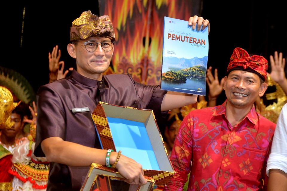 Menteri Pariwisata dan Ekonomi Kreatif (Menparekraf) Sandiaga Salahuddin Uno (kiri) menunjukkan buku tentang potensi wisata kawasan Pemuteran saat pembukaan Pemuteran Bay Festival 2023 di kawasan Gerokgak, Buleleng, Bali, Kamis (16/11/2023). 