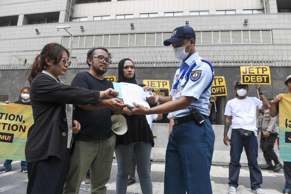 Aktivis yang tergabung dalam gerakan #BersihkanIndonesia menyerahkan dokumen masukan masyarakat sipil di Indonesia kepada petugas usai menggelar aksi teaterikal terkait Rencana Investasi dan Kebijakan Komprehensif (CIPP) Just Energy Transition Partnership