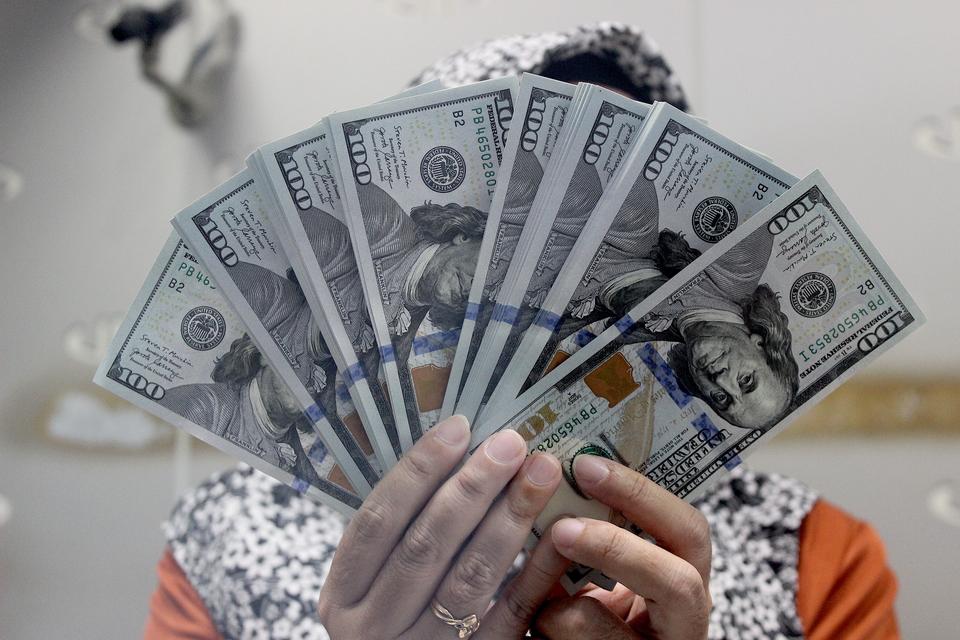 Ilustrasi. Seorang petugas menunjukkan lembaran uang dolar Amerika Serikat di Jakarta, Senin (27/11/2023). Berdasarkan data Bank Indonesia, nilai tukar rupiah menguat berada di level Rp15.494 per dolar AS, menguat 71 poin atau 0,46 persen dari perdaganga