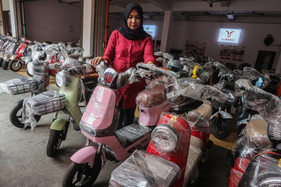 Pramuniaga merapikan kendaraan motor listrik yang dijual di sebuah diler di kawasan Jalan Fatmawati, Semarang, Jawa Tengah, Rabu (29/11/2023).