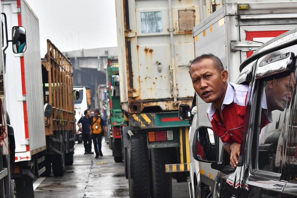 Seorang pengendara terjebak kemacetan saat aksi buruh di kawasan MM 2100, Kabupaten Bekasi, Jawa Barat, Kamis (30/11/2023). Aksi buruh yang menuntut kenaikan UMK (Upah Minimum Kabupaten/Kota) tersebut berdampak kemacetan kendaraan dari Tol Jakarta-Cikampe