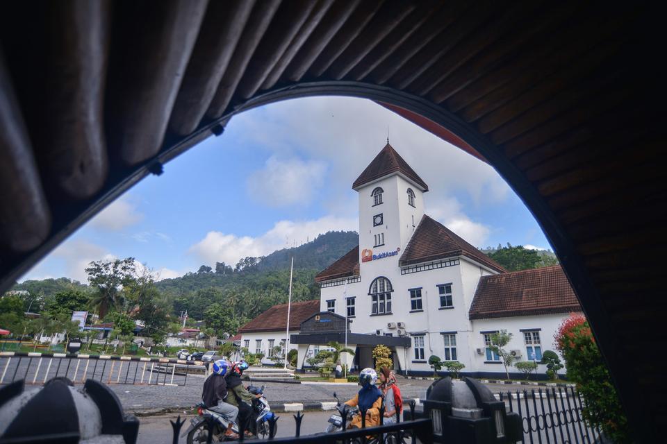 Warga melintas di depan Kantor PT Bukit Asam Ombilin Sawahlunto, Sumatera Barat, Sabtu (2/12/2023). PT Bukit Asam Tbk melanjutkan pembangunan revitalisasi kantornya yang dibangun pada 1916 itu menjadi Hotel Ombilin Heritage tahap kedua dengan 58 kamar dan