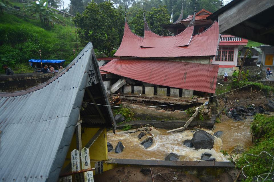 Warga melihat bangunan rusak akibat banjir bandang di Nagari Pariangan, Tanah Datar, Sumatera Barat, Rabu (6/12/2023). Hujan lebat yang mengguyur hulu sungai lereng Gunung Marapi mengakibatkan banjir bandang yang menerjang sejumlah nagari di kabupaten it