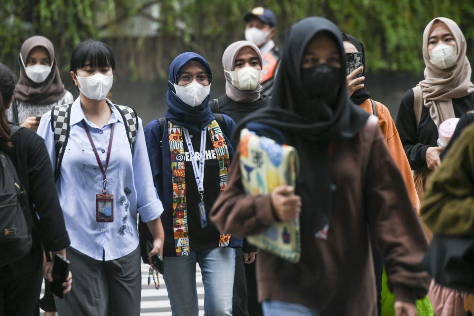 Warga menggunakan masker saat berjalan di Jakarta, Jumat (8/11/2023). Namun, masyarakat diminta tak perlu khawatir dengan Omicron EG.5. 
