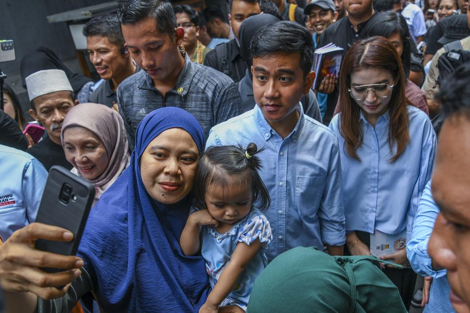 Calon wakil presiden nomor urut 2 Gibran Rakabuming Raka menyapa warga saat melakukan blusukan di Kawasan Cempaka Putih, Jakarta, Sabtu (9/12/2023).